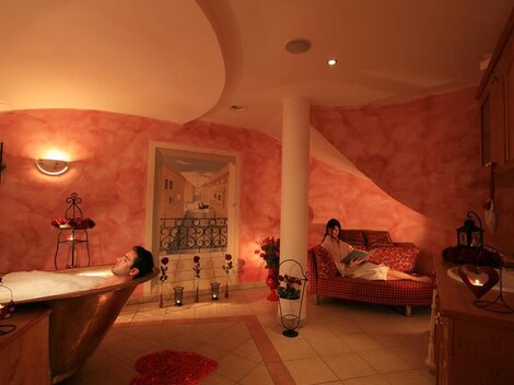 A relaxing bathroom with a bathtub and a cozy couch. Soft lighting and warm colors create a calming atmosphere.