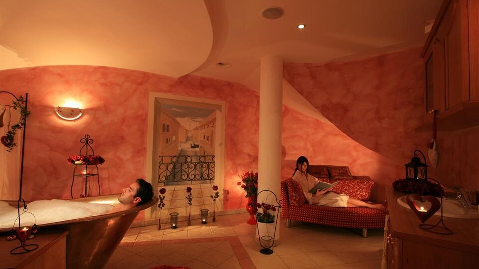 A relaxing bathroom with a bathtub and a cozy couch. Soft lighting and warm colors create a calming atmosphere.