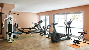 A modern gym with various training equipment. The space is bright and cheerful.