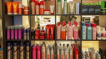 Ein Regal voller Haarpflegeprodukte in verschiedenen Flaschen und Verpackungen. Die Produkte sind bunt angeordnet und umfassen Shampoos, Conditioner und Styling-Hilfen.