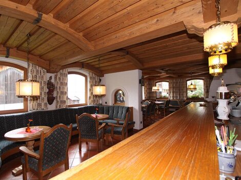 A cozy restaurant with wooden furniture and an inviting atmosphere.  
The windows offer a view of the surroundings, and the pleasant lighting creates a warm ambiance.