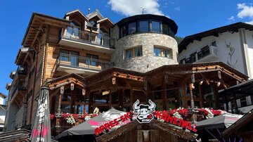 Ein gemütliches Restaurant mit Holzfassade und Terrassen. Blumen und Dekorationen verleihen der Ansicht einen einladenden Charme.