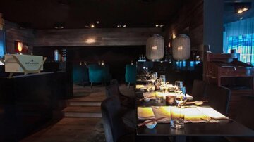Ein stilvolles Restaurant mit gedämpftem Licht und eleganten Möbeln. Die Tische sind liebevoll gedeckt und schaffen eine gemütliche Atmosphäre.