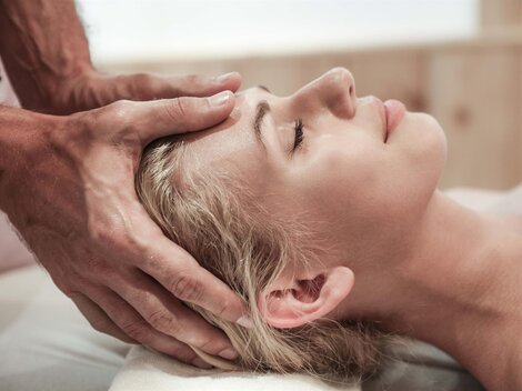 A woman receives a relaxing head massage. The atmosphere is calm and soothing.