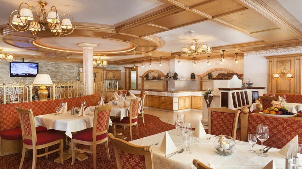 Ein elegantes Restaurant mit holzverkleideten Wänden und gemütlichen Tischen. Die Atmosphäre ist warm und einladend, ideal für ein schmackhaftes Essen.