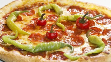 Eine leckere Pizza mit Peperoni und frischen Chilis. Die bunten Chilis verleihen ihr eine besondere Note.