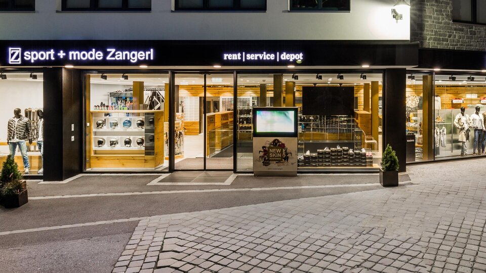 Ein Sportgeschäft mit großen Fenstern, das eine Vielzahl von Sportartikeln zeigt. Die Fassade ist modern und einladend, ideal für Sport- und Modebegeisterte.
