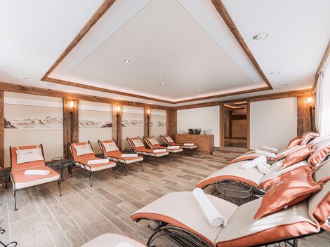 A relaxing wellness area with comfortable loungers and warm colors. The room is bright and modernly designed, ideal for peace and relaxation.